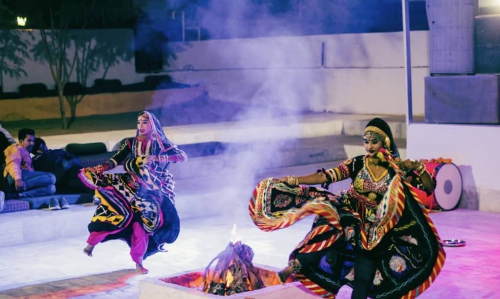 Rajasthani dancers performing around a bonfire at the camp at night