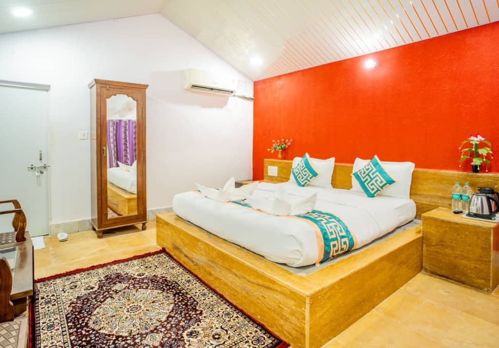 Hotel room with a red accent wall, split air conditioner and wooden platform bed