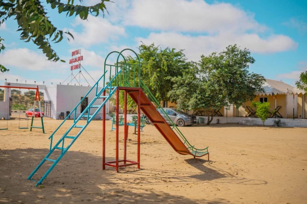 Children's slide and play area in the sand at the Jaisalmer desert hotel