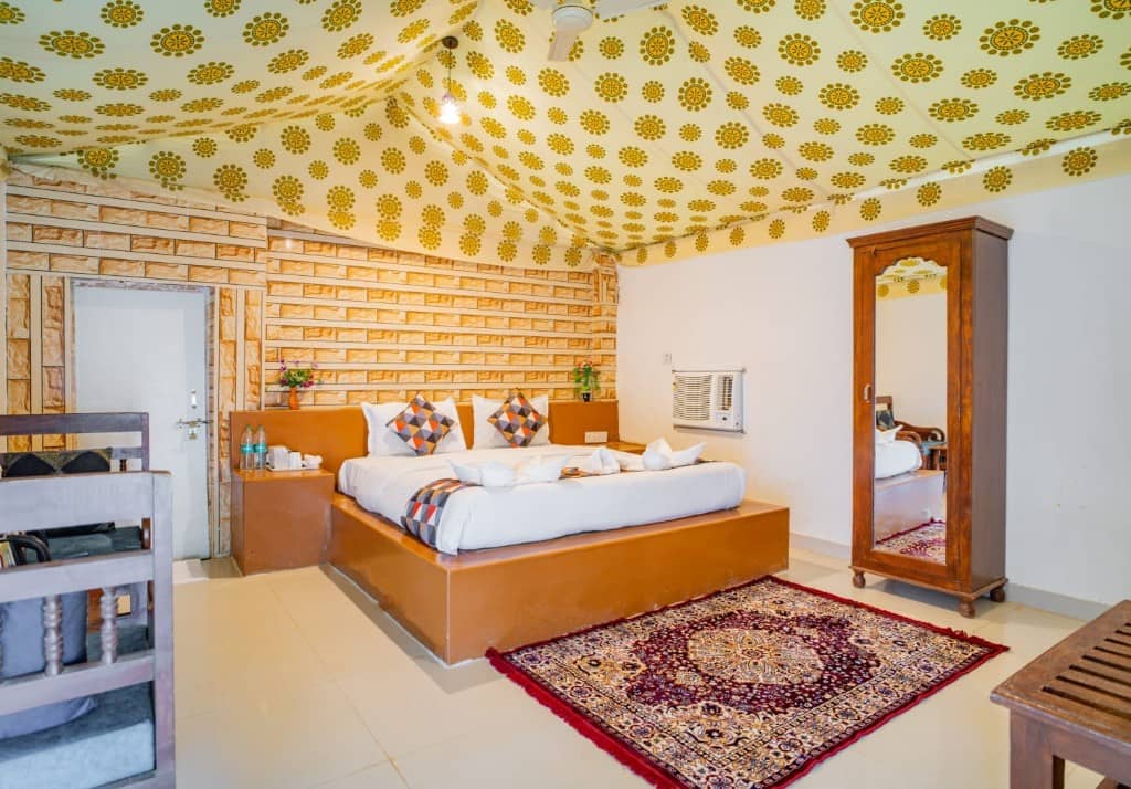 Spacious tent bedroom with a double bed, brick wall, wardrobe and air conditioner