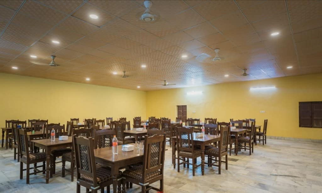 Camp dining hall with wooden tables and chairs set for guests